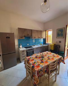 a kitchen with a table with a flowered table cloth on it at GC Petit Palais Lampedusa in Lampedusa