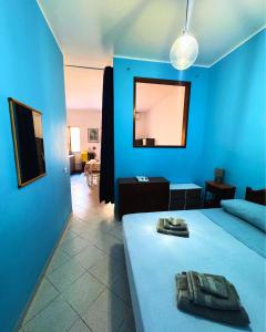 a blue room with a bed and a living room at GC Petit Palais Lampedusa in Lampedusa +2 photos