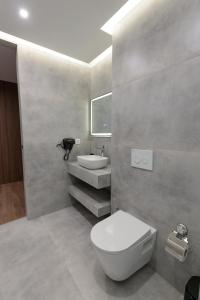 a bathroom with a white toilet and a sink at Velura Hotel & Spa in Ferizaj