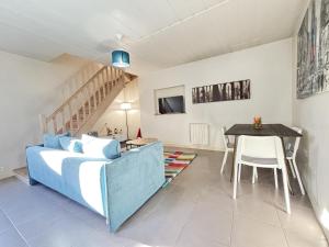 a living room with a blue couch and a table at Maison Cosy & Colorée à Valence-en-Poitou Jardin & Parking in Couhé-Verac