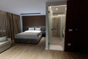 a bedroom with a bed and a walk in shower at Velura Hotel in Ferizaj