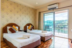 two beds in a room with a balcony at Samprasob Resort in Sangkhla Buri