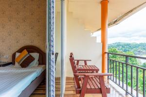 a room with a bed and a chair on a balcony at Samprasob Resort in Sangkhla Buri