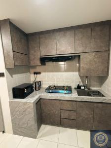 a kitchen with stainless steel cabinets and a sink at Ash Royale Suite - Bercham 138, Bandar Baru Putra, Ipoh, Perak in Kampong Batu Lapan