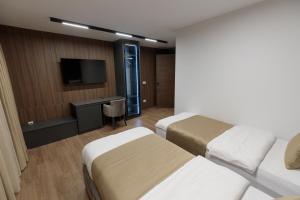 a hotel room with two beds and a desk at Velura Hotel & Spa in Ferizaj