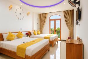 two beds in a hotel room with a clock on the ceiling at Kim Hoàn Hotel Phan Rang in Phan Rang–Tháp Chàm