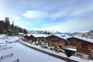 a group of wooden buildings in the snow at Bruyères B22 in Verbier