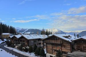 a group of wooden buildings in the snow at Bruyères B22 in Verbier