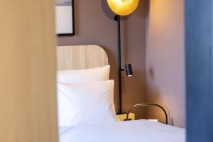 un dormitorio con una cama y una lámpara en Scandic Stuttgart Europaviertel, en Stuttgart