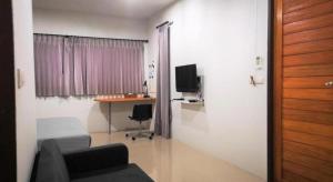 a living room with a couch and a table and a desk at The Lofts Eco Resort in Ban Kut Khamin