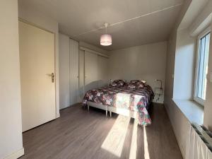 a bedroom with a bed in a room with a window at Maison Cosy & Colorée à Valence-en-Poitou Jardin & Parking in Couhé-Verac