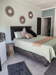 Be Our Guest Near OR Tambo International Airport 2 في بوكسبرغ: غرفة نوم بسرير كبير عليها مخدات +5 صور