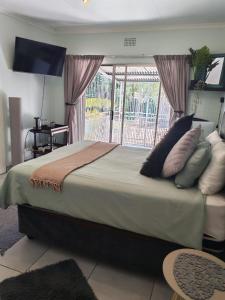 Be Our Guest Near OR Tambo International Airport 2 في بوكسبرغ: غرفة نوم بسرير كبير عليها مخدات