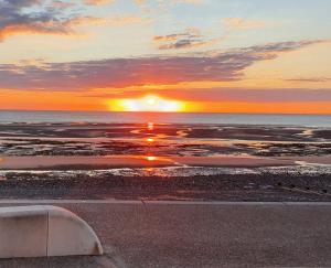 a sunset on the beach with the sun setting at Cleveleys Town Centre in Blackpool
