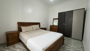 a bedroom with a bed and a black cabinet at Maison Luxueux et Spacieux in Oujda