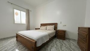 a bedroom with a bed and a dresser and a window at Maison Luxueux et Spacieux in Oujda