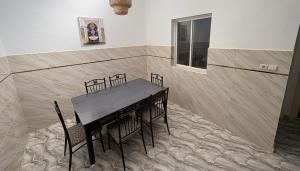 a dining room with a black table and chairs at Maison Luxueux et Spacieux in Oujda +5 photos