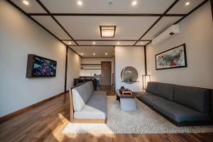 una sala de estar con un sofá y una mesa en Lynntimes Thanh Thủy Wellness Hotel & Resort, en La Phu