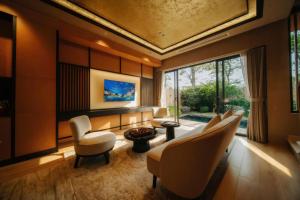 a living room with a couch and chairs and a table at Lynntimes Thanh Thủy Wellness Hotel & Resort in La Phu