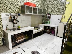 a small kitchen with a sink and a refrigerator at The wilsian - Syariah guest house in Sengkaling +12 photos