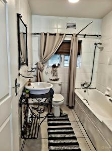 Be Our Guest Near OR Tambo International Airport 2 في بوكسبرغ: حمام مع حوض ومرحاض وحوض استحمام