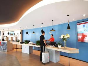 two people standing at a counter in a kitchen at Ibis Ya An Langqiao in Shaping