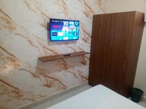 ein Badezimmer mit einem TV an einer Marmorwand in der Unterkunft Résidence Keur Mame Seye 4 in Dakar