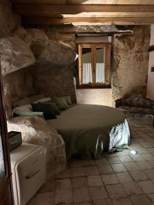 a bedroom with a bed in a stone wall at Paolino848 in Trentinara