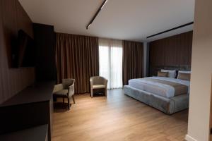 a hotel room with a bed and a desk and chairs at Velura Hotel & Spa in Ferizaj