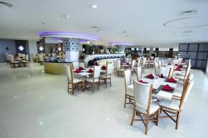 a dining room with tables and chairs in a restaurant at Grand Qin Hotel Syariah in Martapura