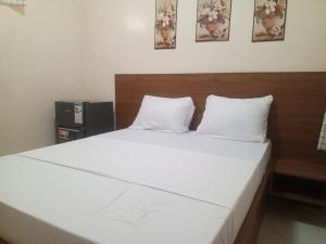ein Bett mit weißen Laken und Kissen in einem Zimmer in der Unterkunft Résidence Keur Mame Seye 4 in Dakar