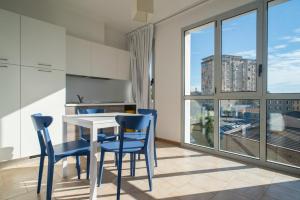 a kitchen with a table and chairs and a large window at Darsena Ravenna Apartments in Ravenna