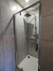 a shower with a glass door in a bathroom at Chambre familiale, Les Brimbelles in Rehaupal