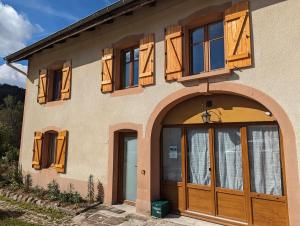 a house with wooden doors and a balcony at Chambre familiale, Les Brimbelles in Rehaupal +7 photos