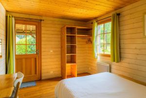 een slaapkamer met een bed, een tafel en ramen bij SAS Le Hameau des Grilles in Saint-Fargeau +99 foto's