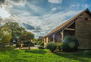 een schuur in een veld met een grasveld bij SAS Le Hameau des Grilles in Saint-Fargeau