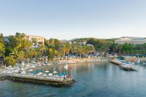 a dock with chairs and umbrellas on a beach at Utopia Resort & Residence in Avsallar
