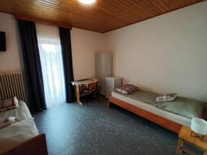 Habitación con 2 camas y escritorio. en Pension Waldfrieden, en Steinhaus am Semmering