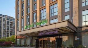 a building with a sign on top of it at ibis Styles Nanjing Qilin Gate Hotel in Qilinmen