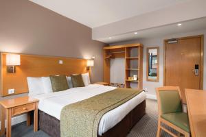 a hotel room with a bed and a desk at Garner Hotel Nottingham City Centre by IHG in Nottingham +104 photos
