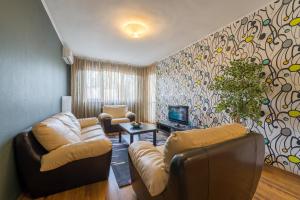 a living room with a couch and a tv at Sofia Central Hotel Apartments in Sofia