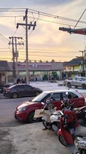 een groep auto's en motorfietsen geparkeerd op een parkeerplaats bij Light Worker Guest House room number 0 in Phra Ae beach