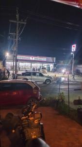 een motorfiets geparkeerd voor een tankstation 's nachts bij Light Worker Guest House room number 0 in Phra Ae beach +2 foto's