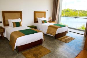 two beds in a hotel room with a large window at Six Elements Beach Villa in Tangalle +39 photos