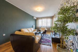 a living room filled with furniture and a large window at Sofia Central Hotel Apartments in Sofia