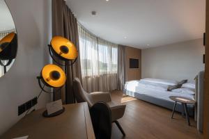 Un dormitorio con una cama y un escritorio con una silla. en Hotel Meilenstein, en Langenthal 59 fotos más