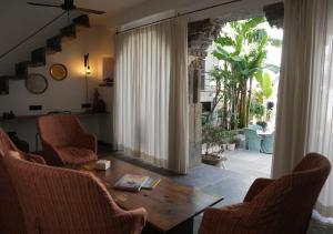 un soggiorno con tavolo e sedie e una stanza con veranda di Little Garden Guest House a Udaipur