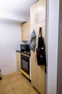 Metris Foxdale Apartments في لوساكا: مطبخ بدولاب خشبي وموقد