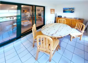 a dining room with a wooden table and chairs at Le Kervenel - Les Gîtes de la Côte d'Amour in Le Croisic