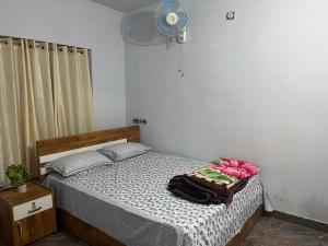 Schlafzimmer mit einem Bett und einem Ventilator in der Unterkunft Tulips villa in Mānantoddy